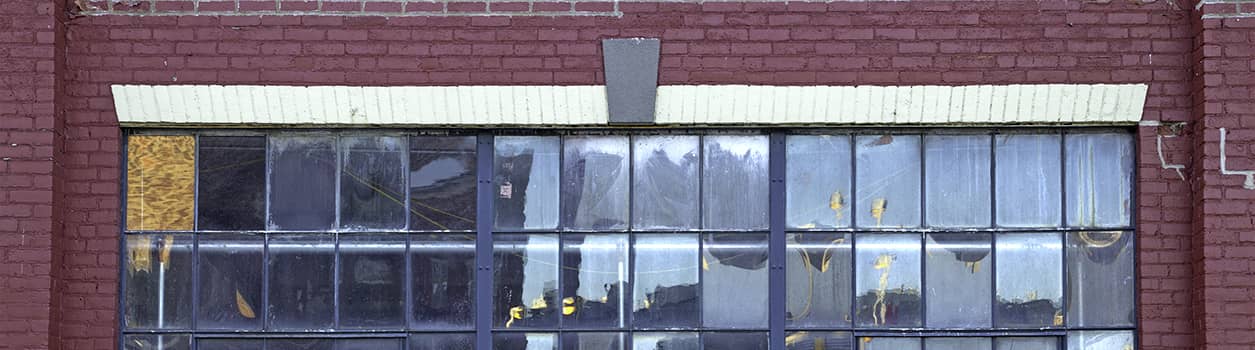 Linteau de brique peinturé en blanc au-dessus d'une fenêtre d'une bâtiment industriel en briques